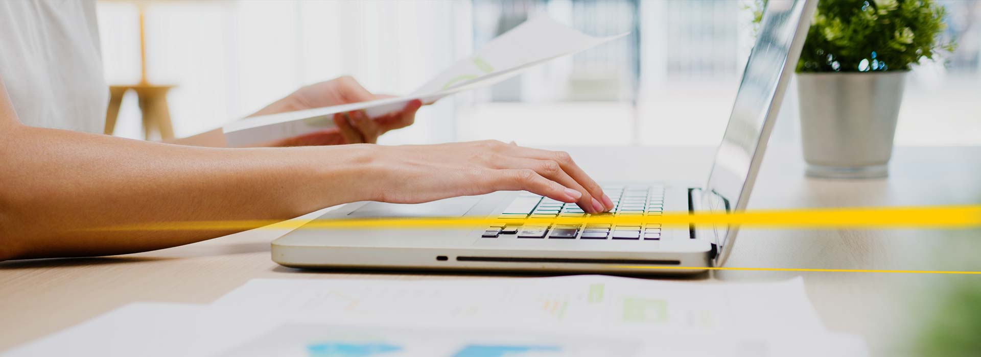 Person on laptop with documents in the hand | LGI